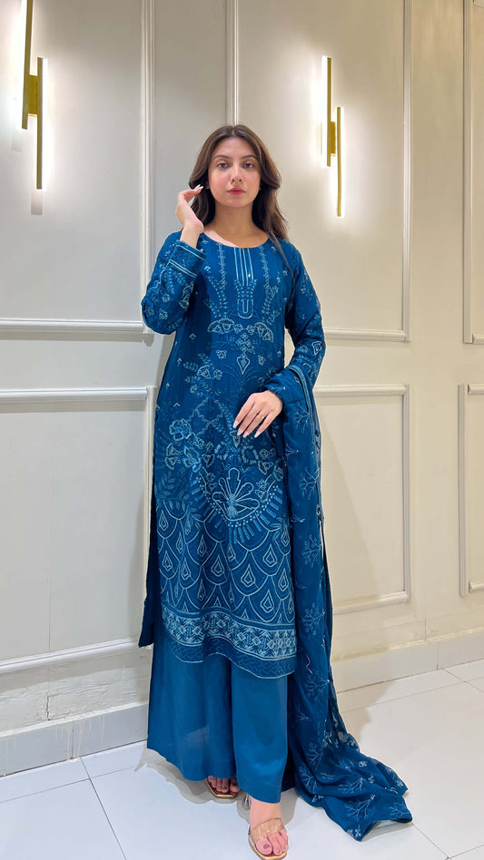 Woman in traditional pose wearing peacock blue embroidered outfit